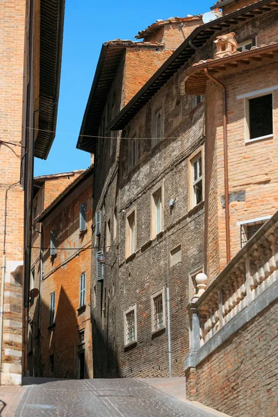 Urbino, Italia - 9 de agosto de 2017: Una pequeña calle en el casco antiguo de Urbino. día soleado. — Foto de Stock