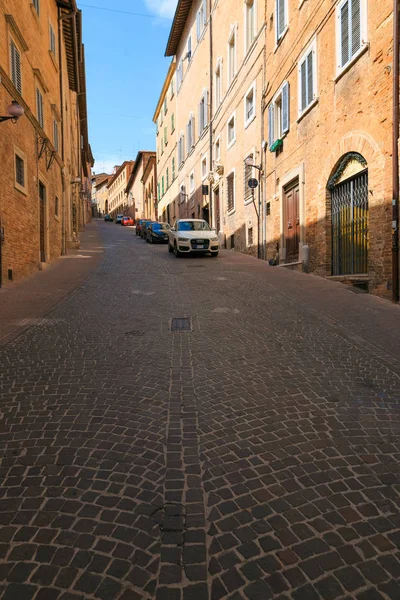 Urbino, Italia - 9 de agosto de 2017: Una pequeña calle en el casco antiguo de Urbino. día soleado. — Foto de Stock