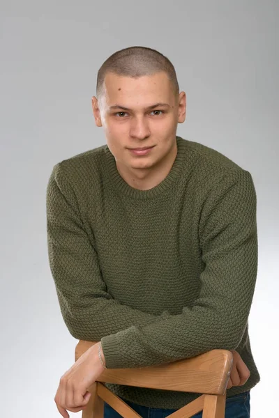 Un giovane uomo è skinhead in un maglione verde stile militare. studio . — Foto Stock