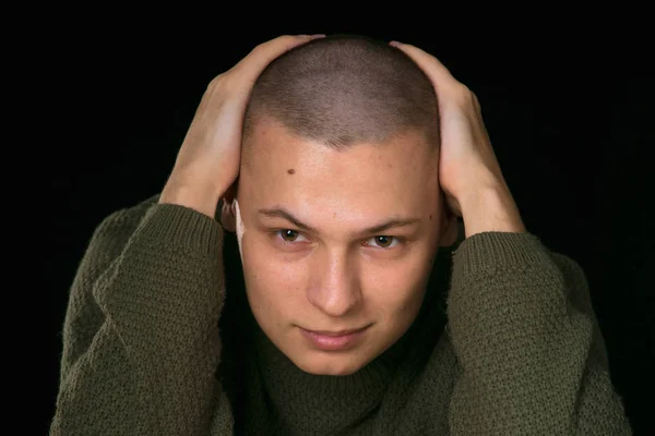 Młody człowiek jest skinhead w zielony wojskowy styl sweter. Studio. — Zdjęcie stockowe