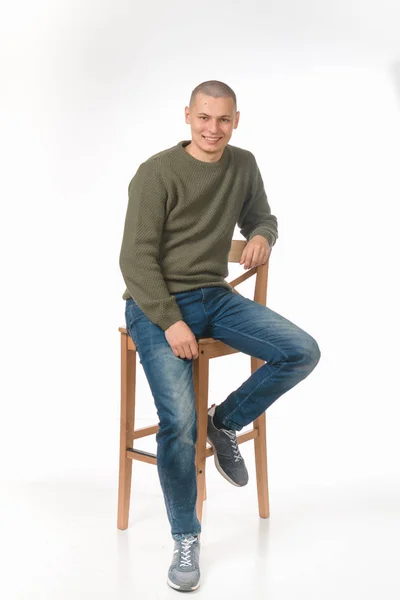 若い男は、緑軍スタイルのセーターのスキンヘッドです。スタジオ. — ストック写真
