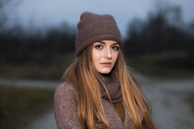 Kız bir örgü şapka ve atkı niteliğine Güz akşamları donuyor.