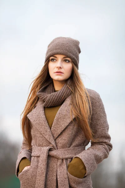 Meisje in een gebreide cap en een sjaal in de herfst op de natuur. koude. — Stockfoto