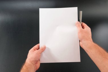 adamın elleri kağıt üzerinde siyah bir arka plan ile. Stüdyo izole.