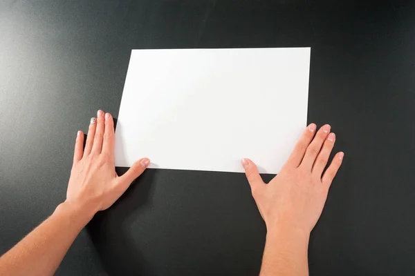 Manos femeninas con papel sobre fondo negro. aislado de estudio . — Foto de Stock