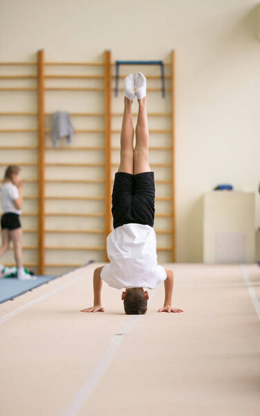 юноша делает гимнастические упражнения в тренажерном зале
.