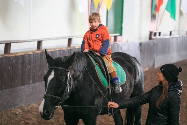 GOMEL, BELARUS - November 25, 2017: Horse riding equestrian sport. Children learn horseback riding. — Stock Photo, Image