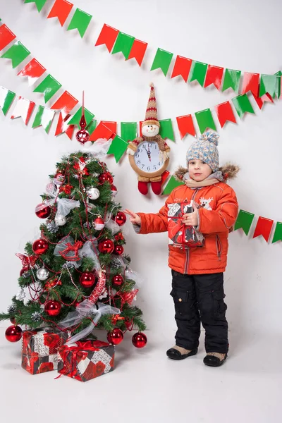 Ragazzo vicino a un albero di Natale su uno sfondo bianco . — Foto Stock