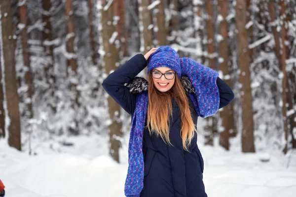 Menina em azul lenço de malha com chapéu na floresta de inverno . — Fotografia de Stock