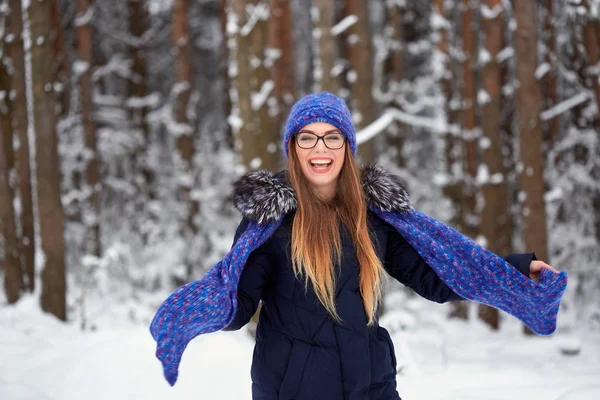 Menina em azul lenço de malha com chapéu na floresta de inverno . — Fotografia de Stock