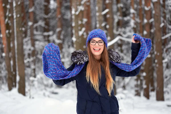 Menina em azul lenço de malha com chapéu na floresta de inverno . — Fotografia de Stock