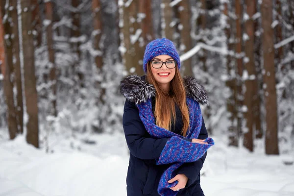 Mädchen in blauem Strickschal mit Mütze im Winterwald. — Stockfoto
