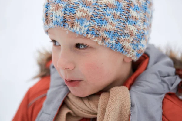 Een jongen in een gebreide winter hoed. — Stockfoto