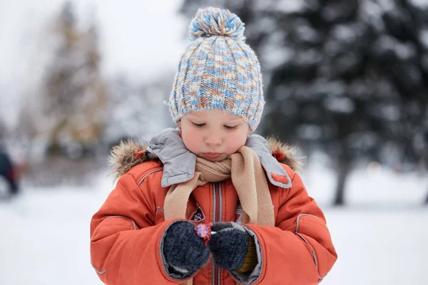 Niño en un sombrero de invierno de punto con caramelos de caramelo . — Foto de Stock