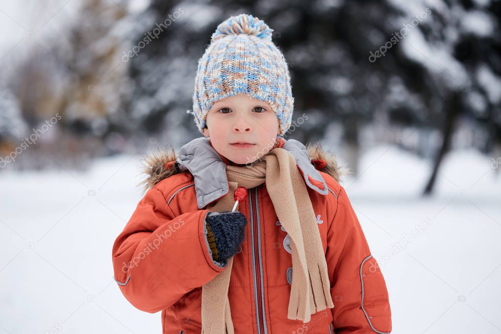 boy in a knitted winter hat with candy candy.