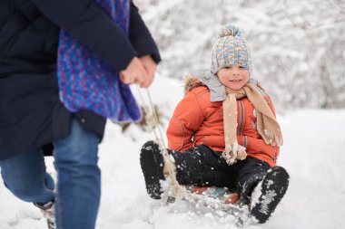 Kış eğlence. Çocuk bir kızak sürme.