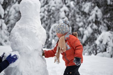 Kış eğlence. çocuğu kardan adam sculpts.