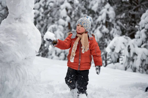 Winter fun. the boy sculpts the snowman. — Stock Photo, Image