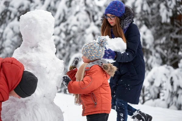 Diversión invernal. una chica y un chico haciendo bolas de nieve . — Foto de Stock
