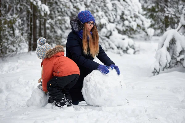 Diversión invernal. una chica y un chico haciendo bolas de nieve . — Foto de Stock