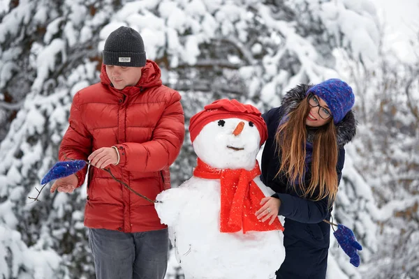 Diversión invernal. una chica y un hombre haciendo bolas de nieve . — Foto de Stock