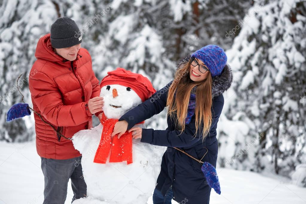 winter fun. a girl and a man making snowballs.