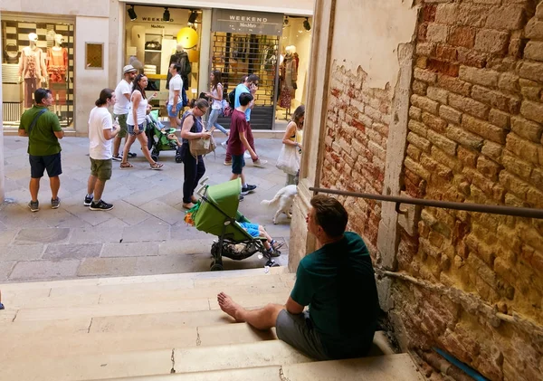 Venecia, Italia - 14 de agosto de 2017: los turistas descansan a la sombra del puente . — Foto de Stock