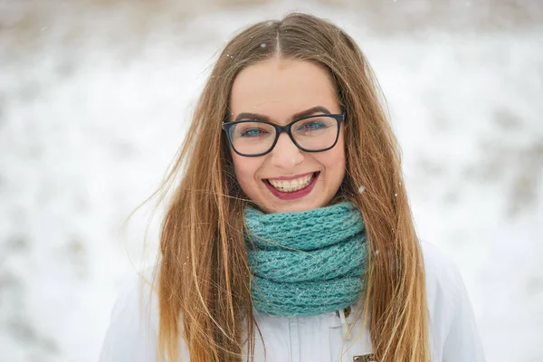 Πορτρέτο του ένα χαρούμενο κορίτσι με τα γυαλιά μια χιονόπτωση το χειμώνα. — Φωτογραφία Αρχείου