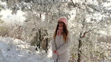 güzel kız pembe şapka ve eldiven bir karlı kış ormandaki.