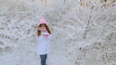 güzel kız pembe şapka ve eldiven bir karlı kış ormandaki.