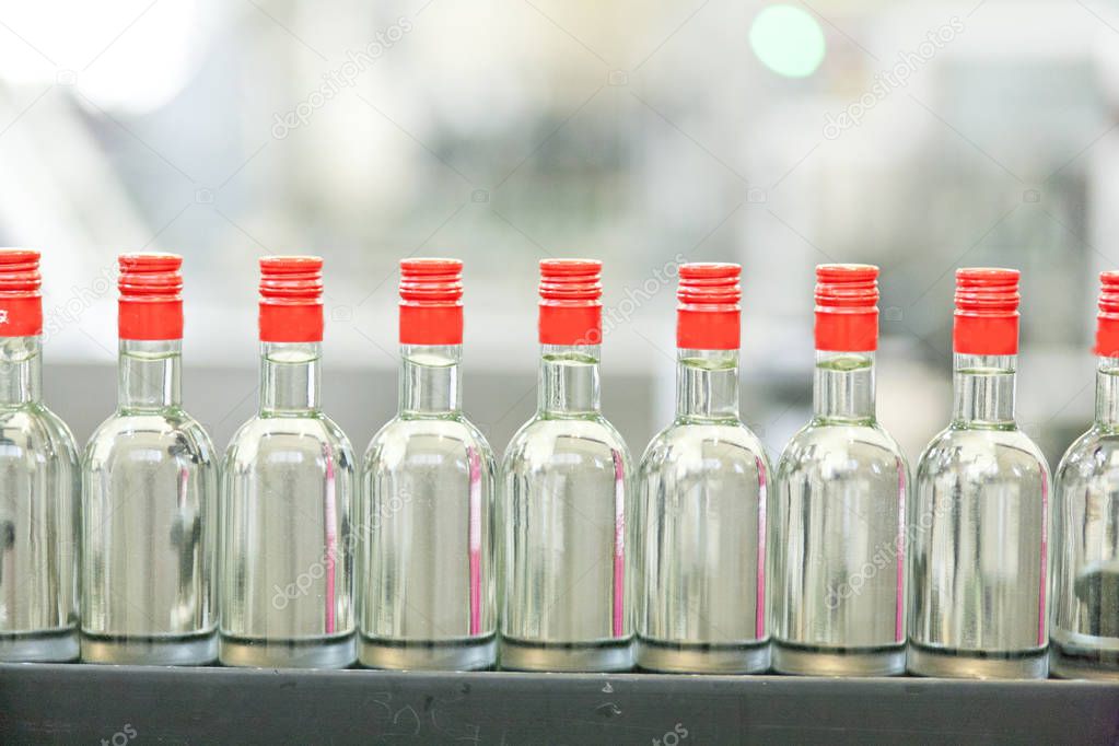 Manufacture of vodka. conveyor with glass bottles.
