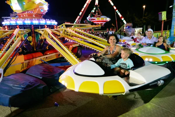 MONTANYAN, ITALIA - 16 DE JULIO DE 2017: Paseos de diversión para niños. tarde en la noche los niños se divierten . — Foto de Stock