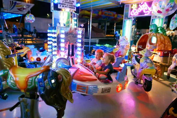 MONTANYAN, ITALIA - 16 DE JULIO DE 2017: Paseos de diversión para niños. tarde en la noche los niños se divierten . — Foto de Stock