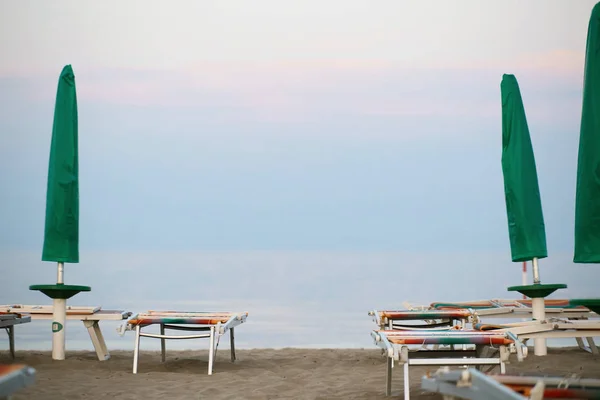 Beach umbrellas by the sea. the evening is deserted. — Stock Photo, Image