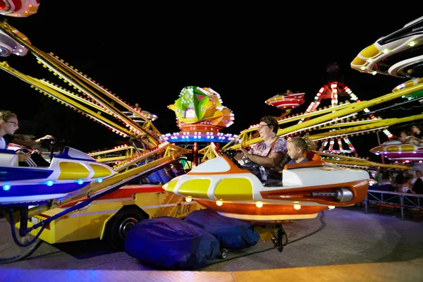 MONTANYAN, ITALY - 16 JULY 2017: Children's amusement rides. late at night children have fun. — Stock Photo, Image