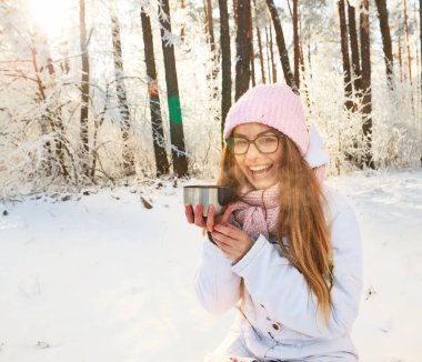 çay bir termos içinde belgili tanımlık kış ormanda içme pembe şapkalı kız.