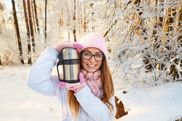 Κορίτσι σε ένα ροζ καπέλο με ένα θερμός το χειμώνα στο δάσος. — Φωτογραφία Αρχείου