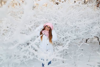 kız kış ormandaki ağaçlar karla kaplı dalları ile. Peri Güzellik.