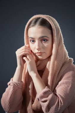 örgü pembe başörtüsü Studio gri bir arka plan üzerinde güzel bir kızın büyük duygusal portre.