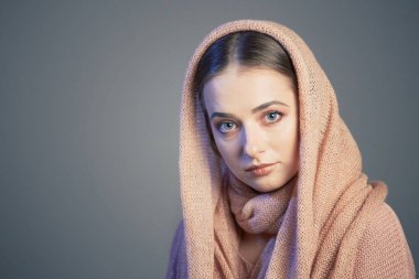 örgü pembe başörtüsü Studio gri bir arka plan üzerinde güzel bir kızın büyük duygusal portre.