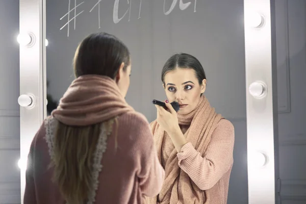 Schönes Mädchen beim Make-up in der Nähe eines Spiegels — Stockfoto