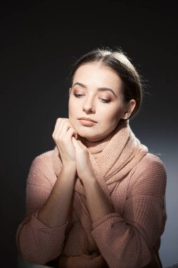 pembe örgü kazak güzel kız. karanlık bir arka plan üzerinde duygusal portre.