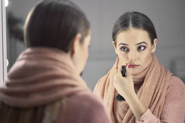 Schönes Mädchen beim Make-up in der Nähe eines Spiegels — Stockfoto