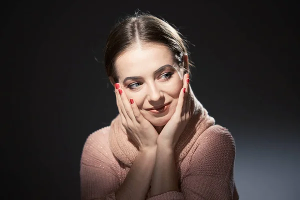 Vacker flicka i rosa stickad tröja. känslomässiga porträtt på en mörk bakgrund. — Stockfoto