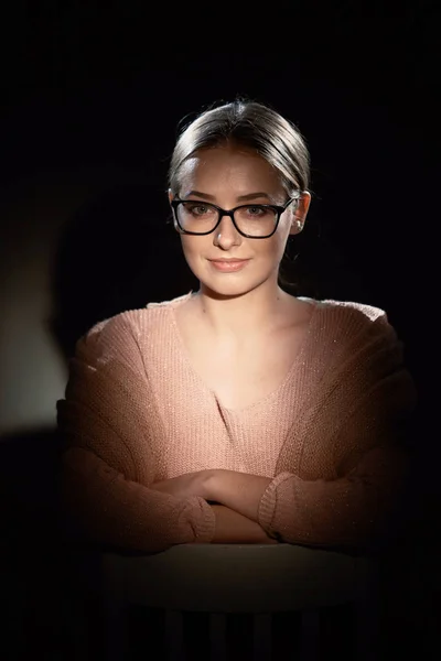 Mädchen mit Brille im Studio auf dunklem Hintergrund. Lichtpunkte. — Stockfoto