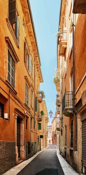 VERONA, ITALIA - 17 de agosto de 2017: Calle estrecha de Verona fachadas de edificios de alto dinamismo . — Foto de Stock