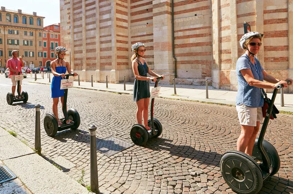 Верона, Італія - 17 серпня 2017: Туристи їздять на напрокат Електроскутер на вулиці в Вероні. — стокове фото