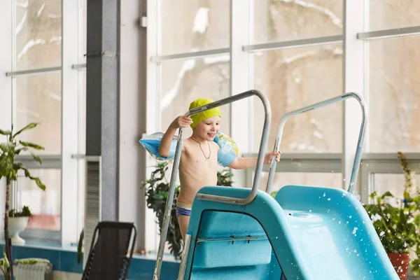 GRODNO, Belarús - Balneario Porechye. Niños esquiando con un tobogán acuático nadando en la piscina . — Foto de Stock
