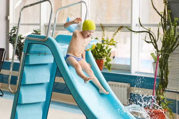 GRODNO, Belarús - Balneario Porechye. Niños esquiando con un tobogán acuático nadando en la piscina . — Foto de Stock