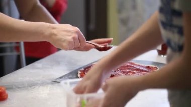 Çocuk el pizza hazırlamak. hamur üzerinde dolgu yaymak.